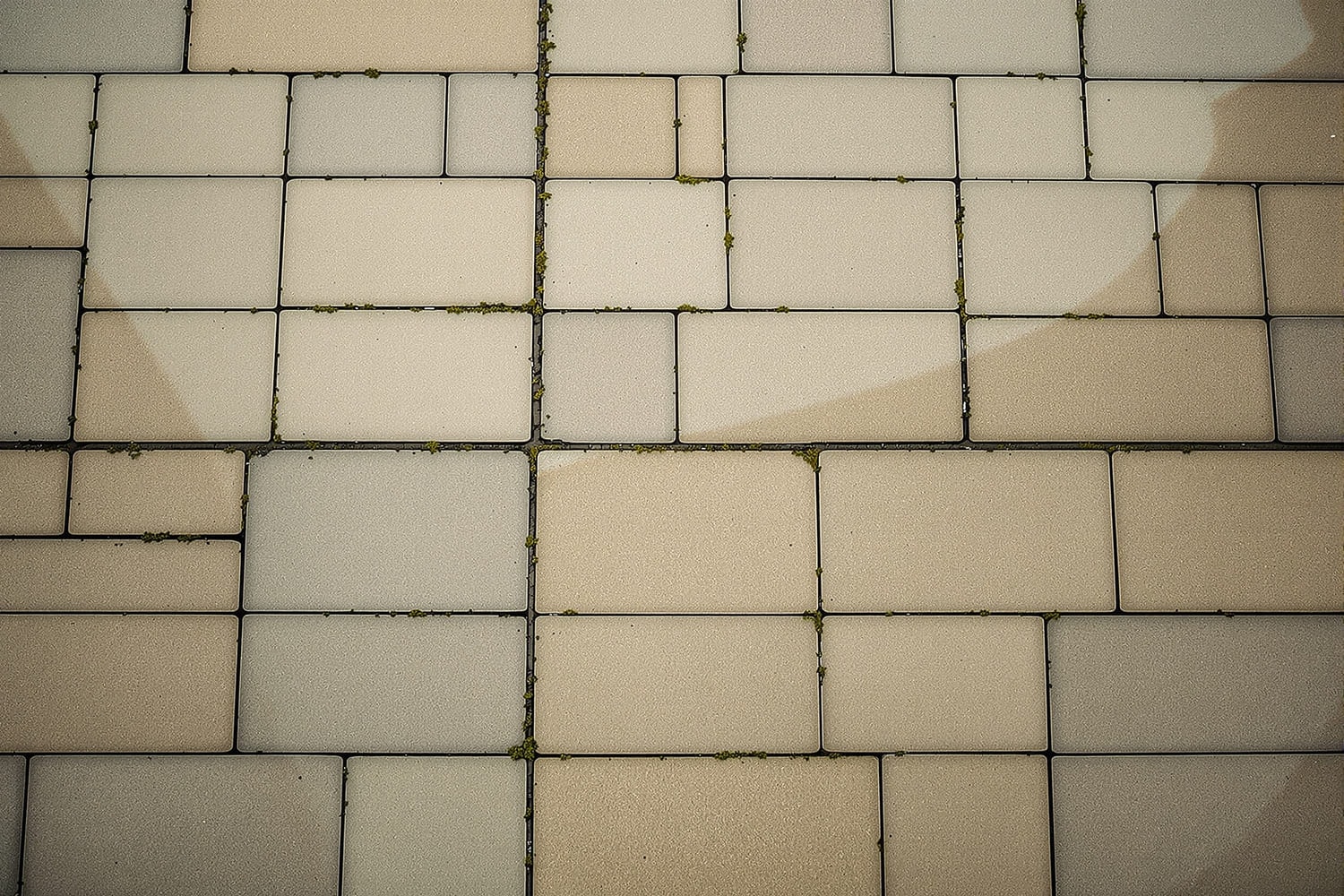 An overhead view of a stone plaza paved in large square flags, one broad joint running through the middle
